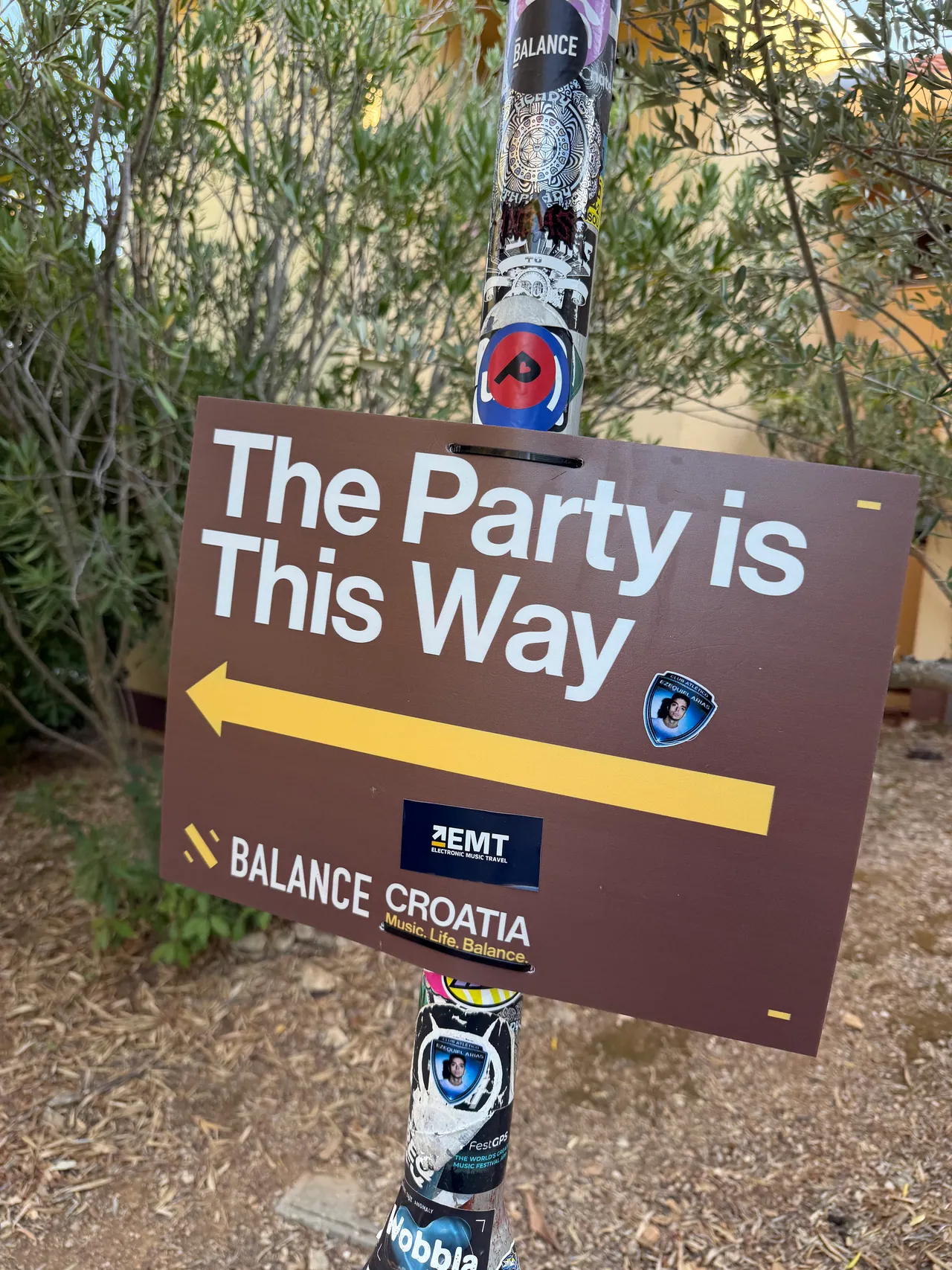 Cartel The Party is This Way con un sticker EMT